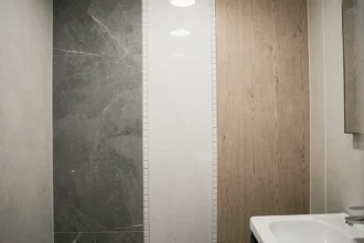 Comparaison de trois finitions de dalles PVC murales dans une salle de bain moderne : mat, brillant et effet bois