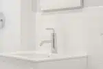 stainless steel faucet on white ceramic sink