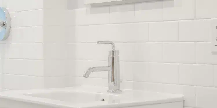 stainless steel faucet on white ceramic sink