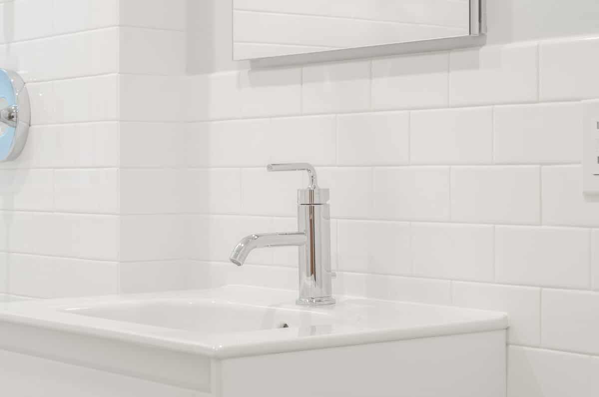 stainless steel faucet on white ceramic sink