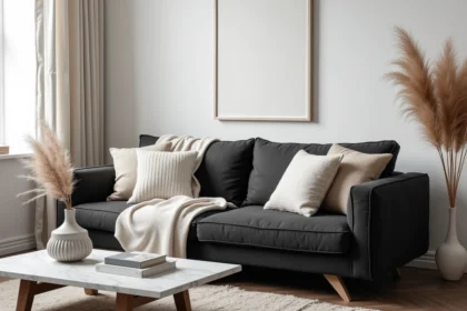 Salon cosy en noir et blanc avec canapé en lin anthracite, coussins ivoire et parquet en chêne foncé